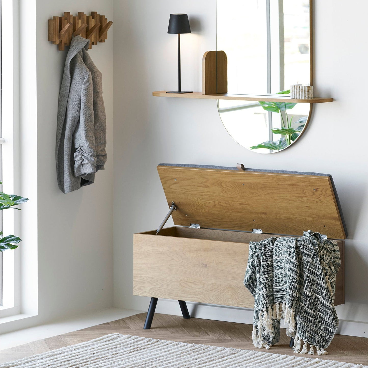 Adana plaid - groen nordic design motief - gedrappeerd over opbergkist in een scandinavische inkomhal