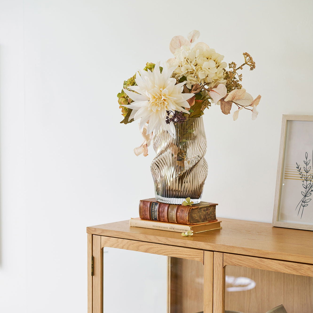 Bruine Lykke vaas op een houten kast met bloemen in