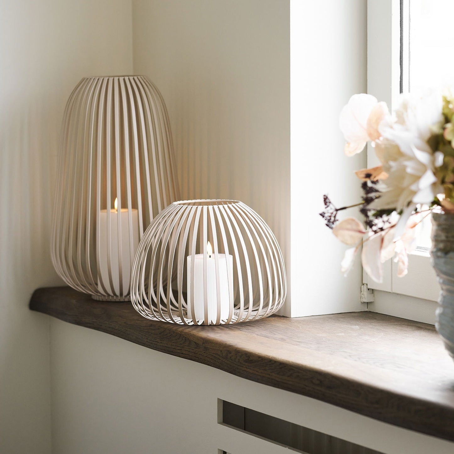 Stoense hygge lantaarn set - brede en hoge lantaarn in beige metaal op stijlvol houten scandinavische vensterbank