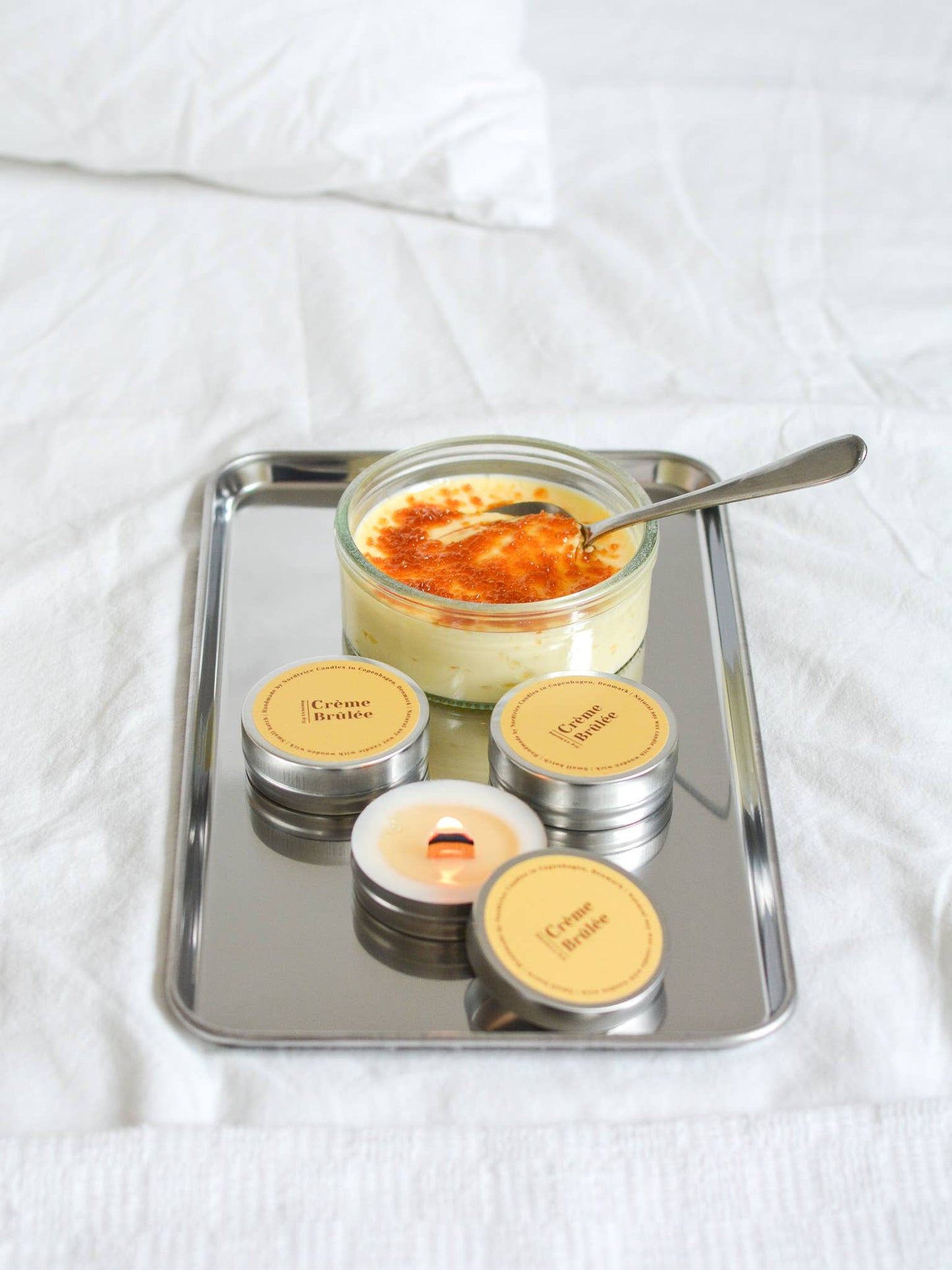 Nordtrice handgemaakte mini Crème Brûlée geurkaars - brandende kaars samen met een crème brûlée op plateau