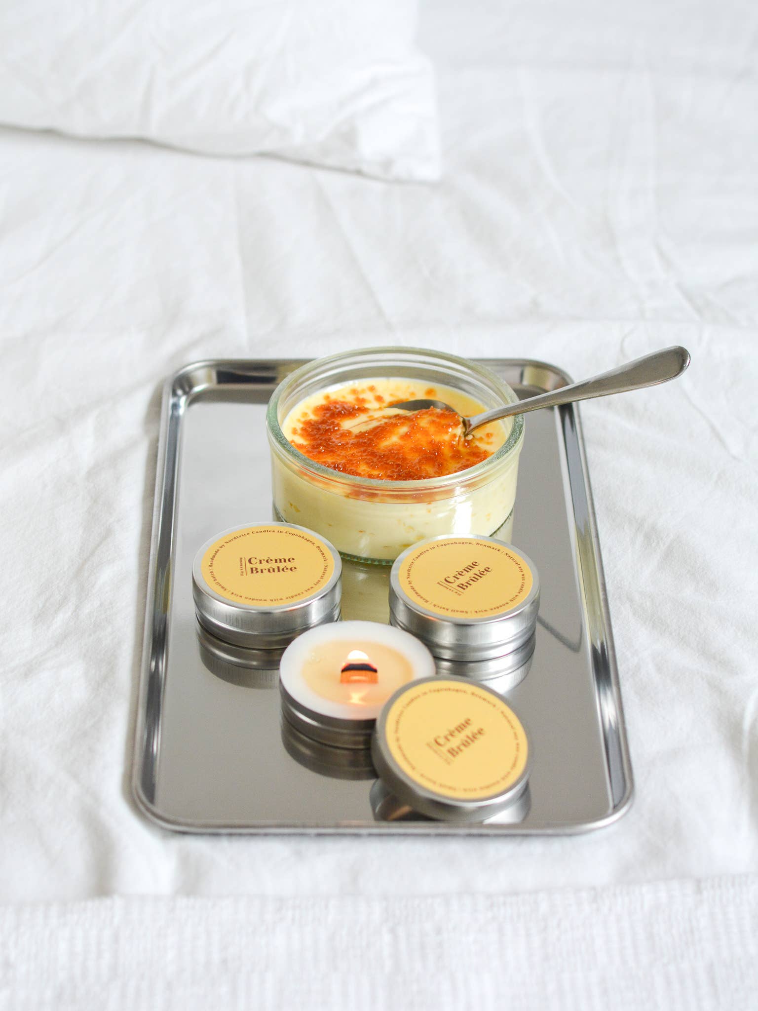 Nordtrice handgemaakte mini Crème Brûlée geurkaars - brandende kaars samen met een crème brûlée op plateau