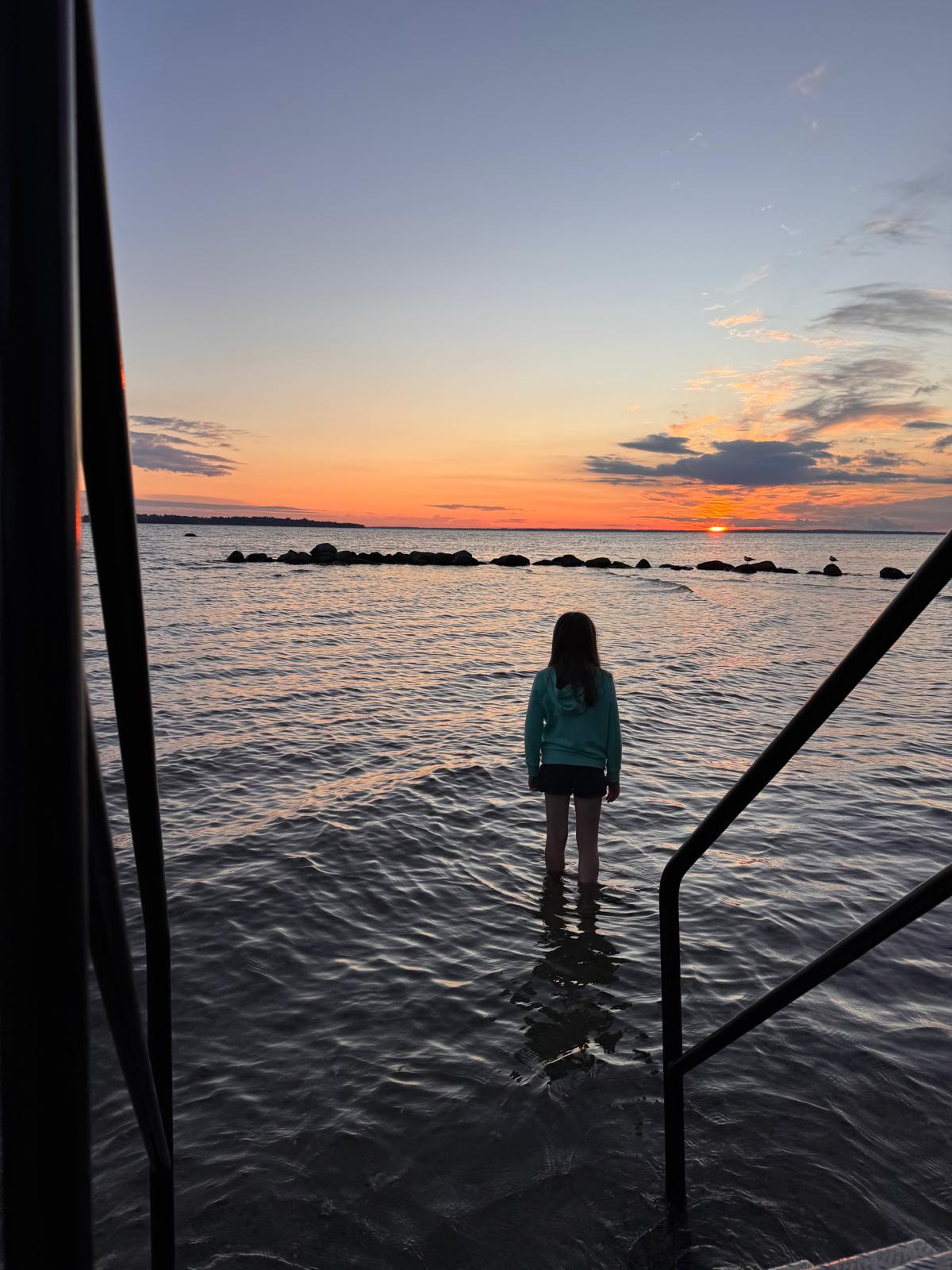 Kijken naar de zonsondergang met de voeten in het water