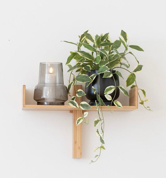 Grijs gerookte vaas met kaars op een houten wandplak - minimalistische scandinavische wanddecoratie